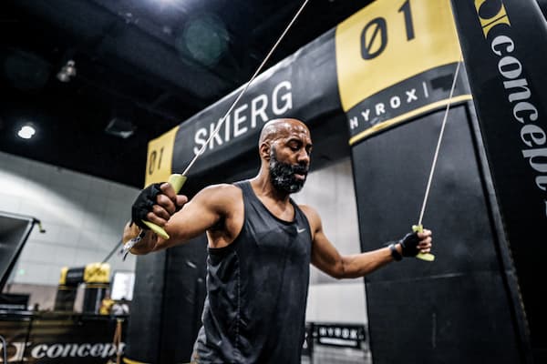 An athlete training on a Concept2 SkiErg machine at a HYROX fitness competition