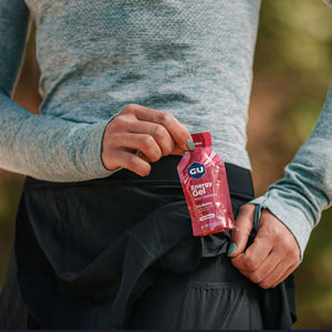 Woman pulling out a packet of gu energy gel