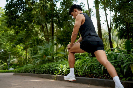 Runner stretching calves outdoors in park