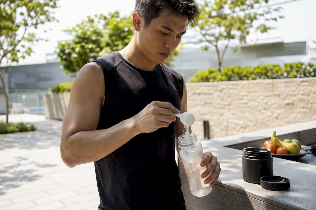 Athlete mixing creatine drink in kitchen