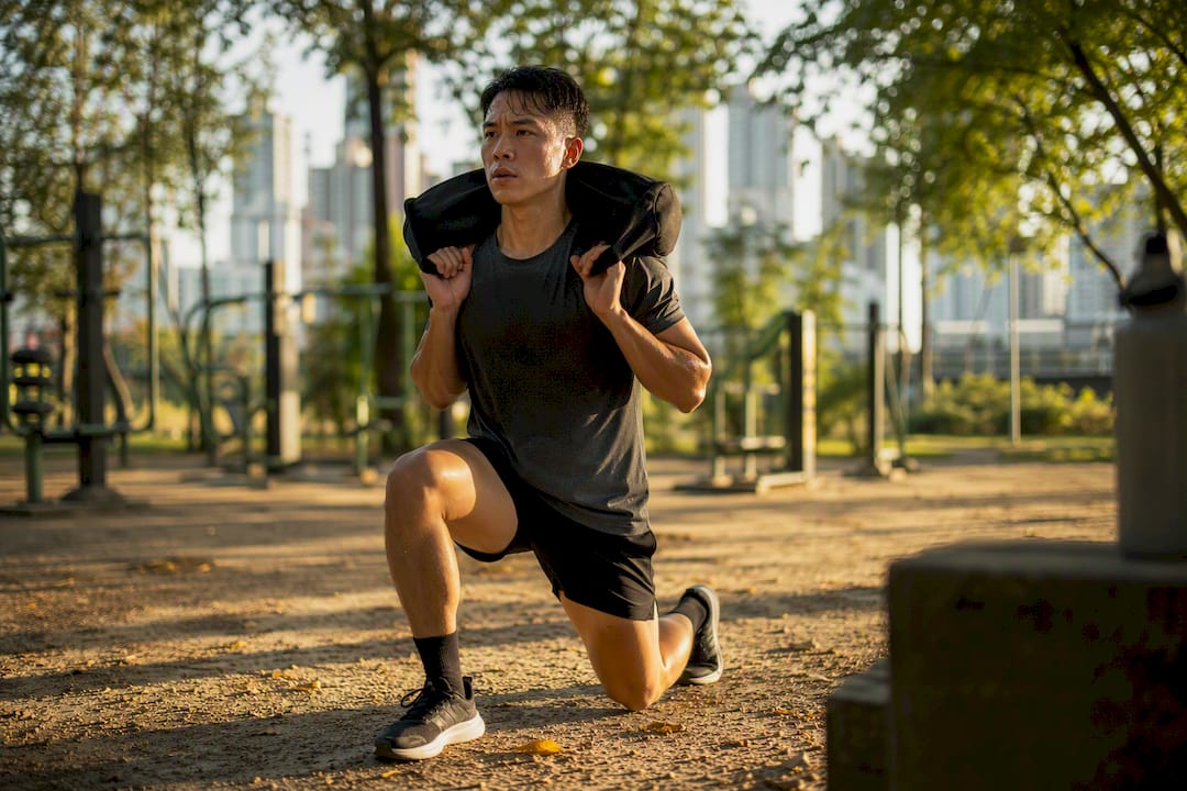 Athlete running and lunging with sandbag