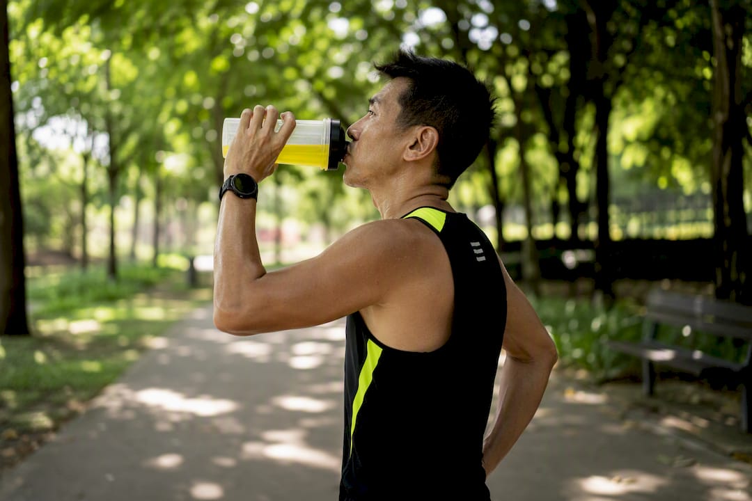 Athlete hydrating with electrolyte drink on trail