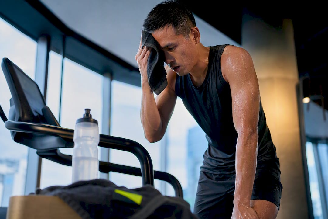 Sweaty athlete beside hydration bottle