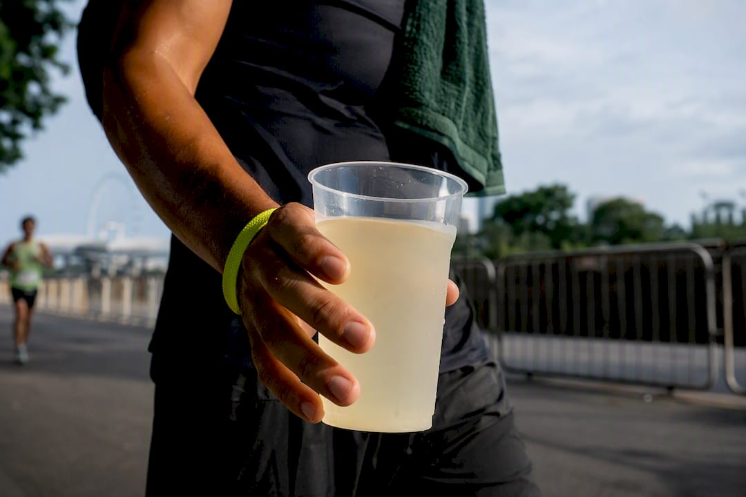 Athlete holding sports drink at race station