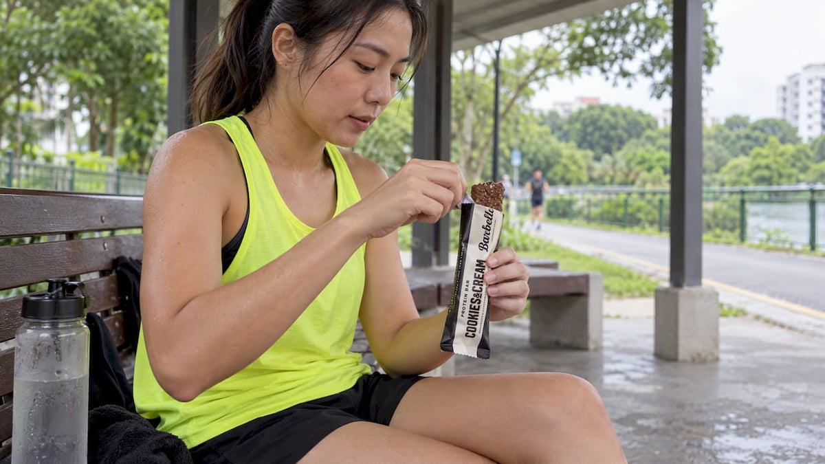 Runner opening a Barebells protein bar