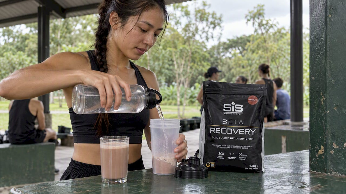 Runner preparing recovery drink beside protein shake