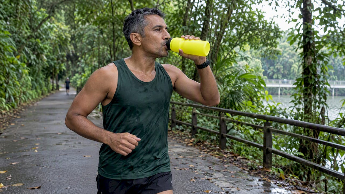 Runner drinking water on a humid Singapore path